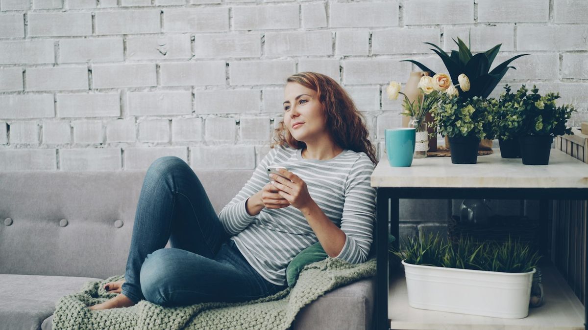Mujer relajada en el sofá con un café